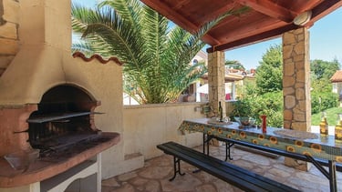 Shared barbecue and outdoor dining area by the pool in Volme