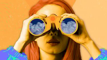 a woman with red hair and a blue shirt holding binoculars