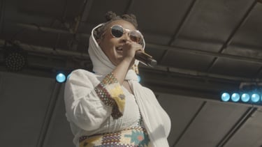 A person performing on a stage holding a microphone.