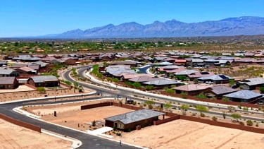 a city street with a lot of houses and mountains in the background