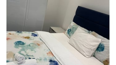 a well kept bed with a blanket and towels on it