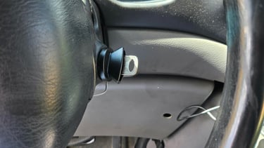 Car key I replacement inserted in the ignition near the steering wheel