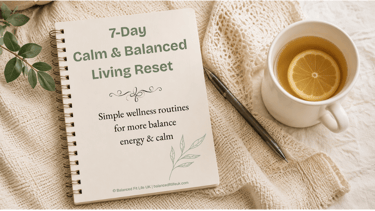 A 7-Day Calm and Balanced Living Reset wellness guide on a spiral notebook next to lemon tea.
