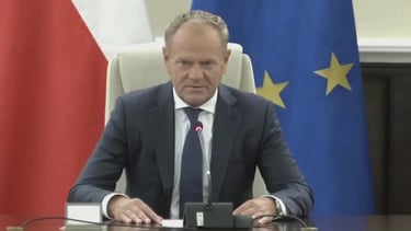 a man in a suit and tie is sitting at a desk