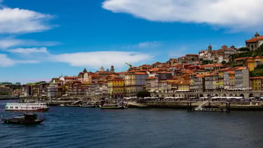 a river with boats and buildings in the background