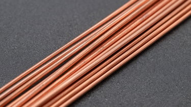 Détail macro d'un faisceau de fils de cuivre dénudés, brillants et parfaitement torsadés, prêts à être connectés, sur un fond anthracite, éclairage studio mettant en valeur la texture métallique, haute-contraste.