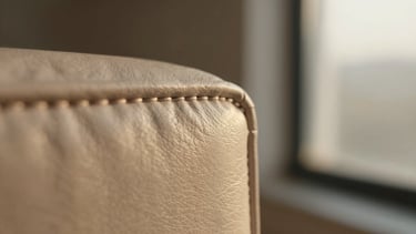 Extreme macro shot of precise, thick hand-stitched seams on a structured leather edge, warm golden hour light, 35mm photography