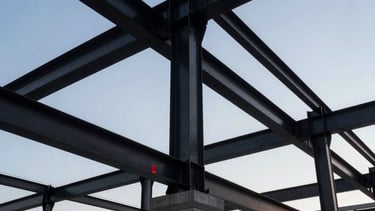 A low-angle architectural photograph of a high-end commercial roof structure in New York City. Steel black beams and concrete gray textures are prominent against a twilight sky. The lighting is sharp and professional, highlighting the engineering precision of the framework. Structural red safety markers are subtly visible, emphasizing safety and integrity.