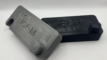 Custom 3D printed radio cases in grey and black featuring the ICOM brand logo.