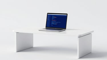 Minimalist panoramic 3D render of a workspace with clean white desks and a laptop displaying structured code, bright high-key studio light, minimalist white and electric blue, sharp focus