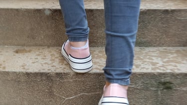 a person walking up some stairs with their feet on the ground