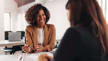 a woman in a business suit sitting at a table