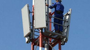 Close-up of a technician adjusting radio communication equipment in a control room.