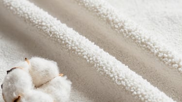 Selection of organic cotton and bamboo fabrics laid out on a wooden table