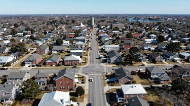 Wide aerial view of Medway, Massachusetts, showing residential areas and main roads, centered on 106 Main St, under bright daylight, professional service photography, sharp focus, 35mm