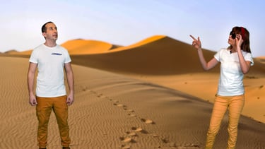 a man and woman standing in a desert