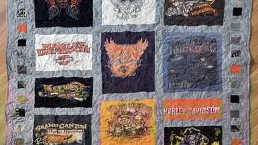T-shirt memory quilt made from printed shirts arranged in quilt blocks.