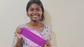 Girl holding up a Hanaru reusable sanitary napkin.