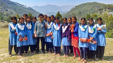 Hanaru's founder, Kayoko Govindasamy standing with a group of girls who have just received Packs..