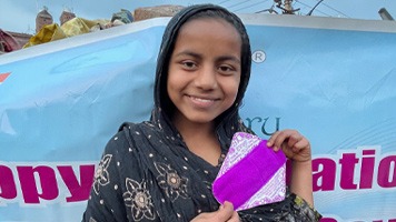 Girl holding up a reusable sanitary napkins.