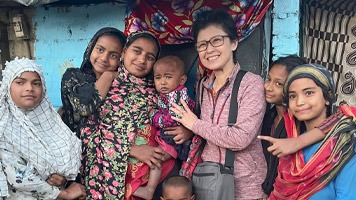 Kayoko with a family outside a slum home.