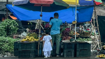 Fruit and vegetable stand in West Bengal with tarp over top.