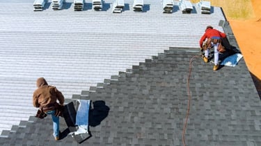 sky view of 2 workers installing roof tiles