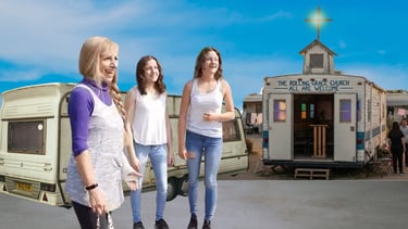 A mobile community center and the Rolling Grace Church trailer with people gathered outside.