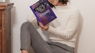 Girl sitting on floor reading Creator To King of Kings bible study 