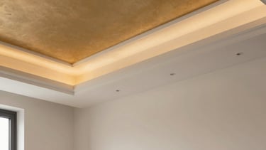 Architectural photography of a luxurious living room in a Southern European / Italian apartment. The focus is on a sophisticated coffered drywall ceiling with amber gold recessed lighting. The walls are a smooth off-white finish. The composition is clean and modern, highlighting professional craftsmanship and elegant construction details.