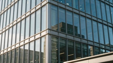 A clean, architectural shot of a contemporary office building exterior with glass and steel elements. The lighting is crisp morning light, reflecting a sense of clarity and professional expertise. Located in a North American urban center.