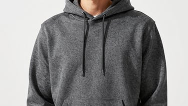 Bright editorial apparel photography of a model wearing a heavy-duty charcoal hoodie, clean industrial daylight, high-contrast crisp tones, 35mm medium format