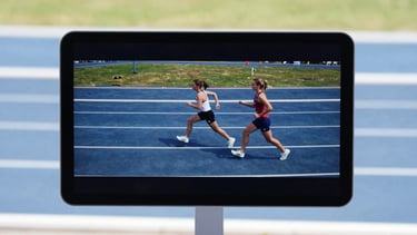 A crisp video playback screen of an active track coaching session, bright natural lighting, sharp focus.