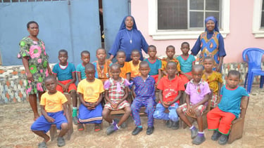 A group of African school children and teachers posing for a photo at a local community school.