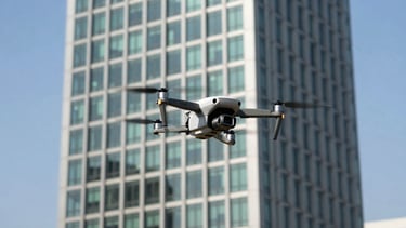 A high-tech drone hovering precisely over a modern Luanda office tower, sharp focus, clear blue sky, professional technical inspection