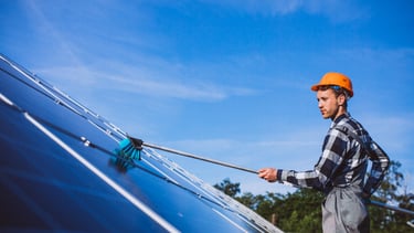 Technicien nettoyant un panneaux solaire sur une toiture dans le département de la Creuse