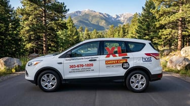 XL Carpet Care professional service vehicle parked in Evergreen, Colorado with a view of the Rocky Mountains.