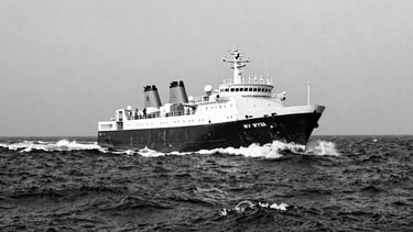 Archival black-and-white panoramic photograph of the MV Wyuna cutting through heavy seas, dramatic, powerful, 21:9 frame, low horizon, 35mm lens.