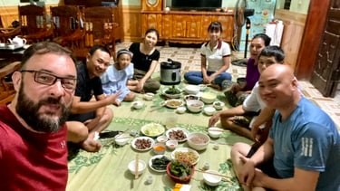 a group of people sitting around a table with food