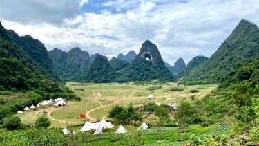 a mountain view of a valley with tents