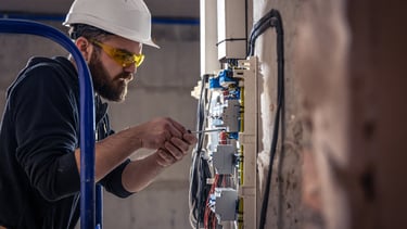 Tra technician installing HVAC ducts at a commercial project site