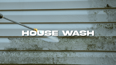 a person using a hose to clean a house