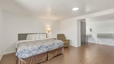 Renovated room with one king bed, large TV, wood flooring at Patriot Stay Motel in Vernal UT 