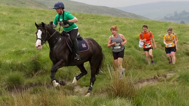 Man v Horse. Runners and Horse together on the course.