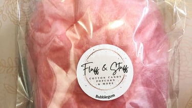 a small bag of pink cotton candy with a sticker on it