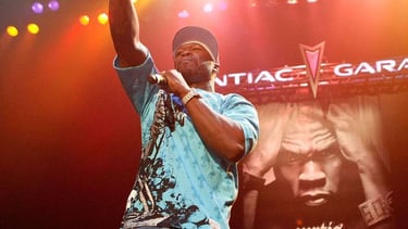 Rapper 50 Cent performing live on stage with a microphone during his Curtis album concert tour.