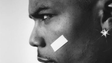Black and white profile portrait of Nelly featuring his signature face band-aid and diamond earring.
