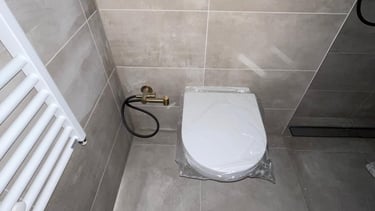 Nieuw geïnstalleerd wandtoilet en verwarmingsradiator in badkamer in Rotterdam-Hoogvliet