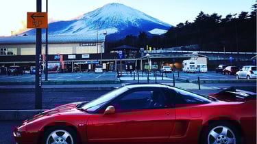 a red sports car parked in front of a mountain