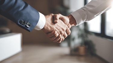 two people shaking hands in a room